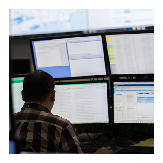 People looking at computer screens to monitor IT network security.