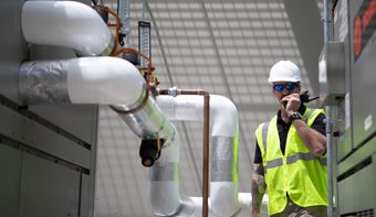 man in hardhat talking on a radio