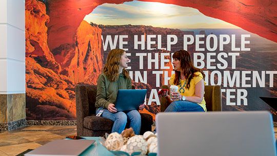 Two women sitting in an office talking