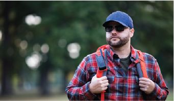 Man walking in forest with red t210 on backpack